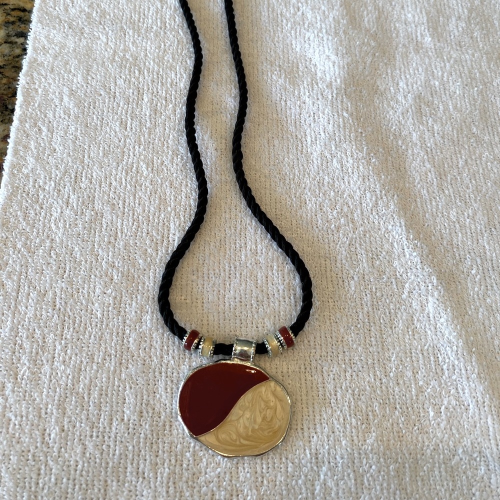 Black cord with red/cream enamel pendant